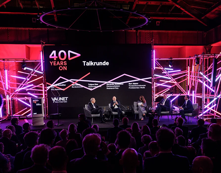 TV studio with 5 people on the stage of a talk show about "40 years on" – 40 years of private TV. In the foreground you can see the audience. (Photo)